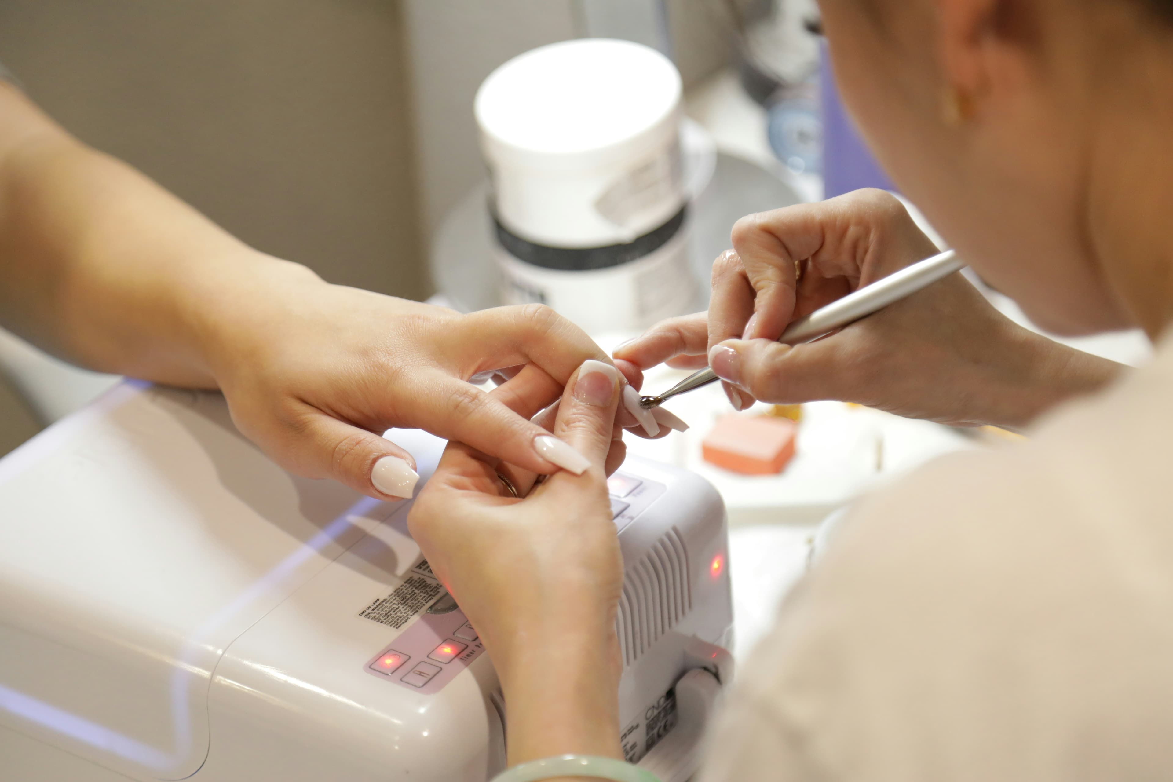 A nail technician painting a client's nails