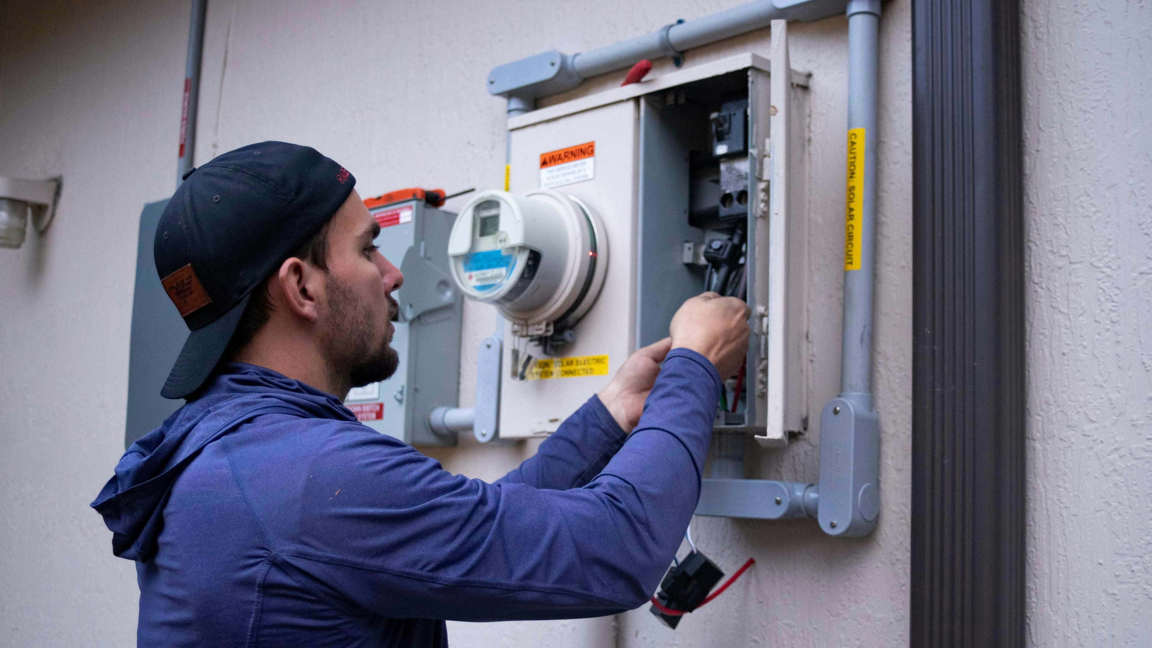 An electrician working on an electricity meter